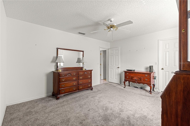 carpeted bedroom featuring a ceiling fan, visible vents, a textured ceiling, and baseboards