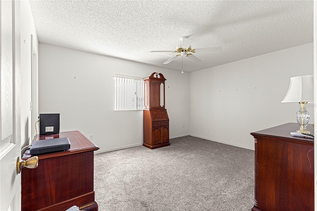 carpeted home office with ceiling fan, a textured ceiling, and baseboards