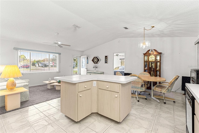 kitchen featuring lofted ceiling, visible vents, light countertops, and a center island