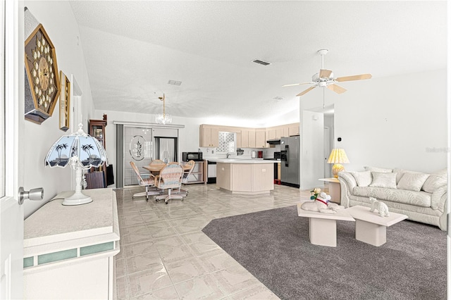 living room featuring a ceiling fan, visible vents, vaulted ceiling, and a textured ceiling