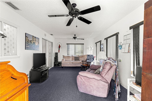 carpeted living area with a textured ceiling and visible vents