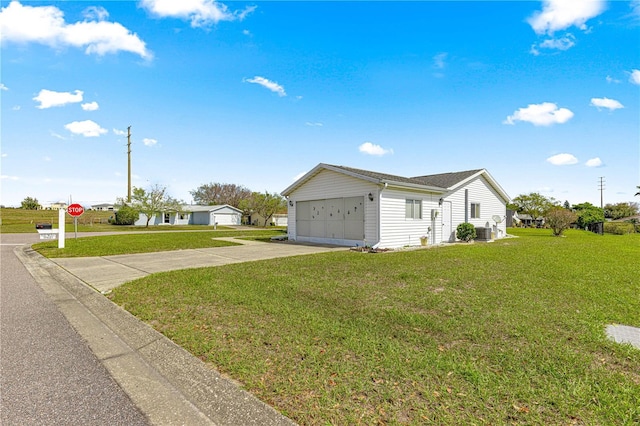 view of side of home featuring a lawn and concrete driveway