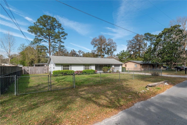 view of front facade featuring a fenced front yard, a front yard, and a gate