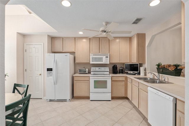 kitchen with light brown cabinets, white appliances, a sink, visible vents, and light countertops