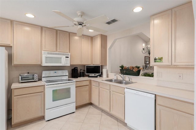 kitchen with light countertops, visible vents, light brown cabinets, a sink, and white appliances