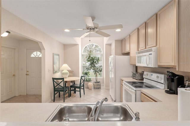 kitchen with light tile patterned floors, light brown cabinets, white appliances, a sink, and light countertops