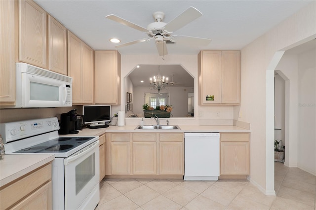 kitchen with white appliances, light countertops, a sink, and light brown cabinetry