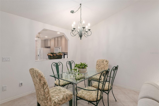 dining space featuring light tile patterned floors, baseboards, arched walkways, and a notable chandelier