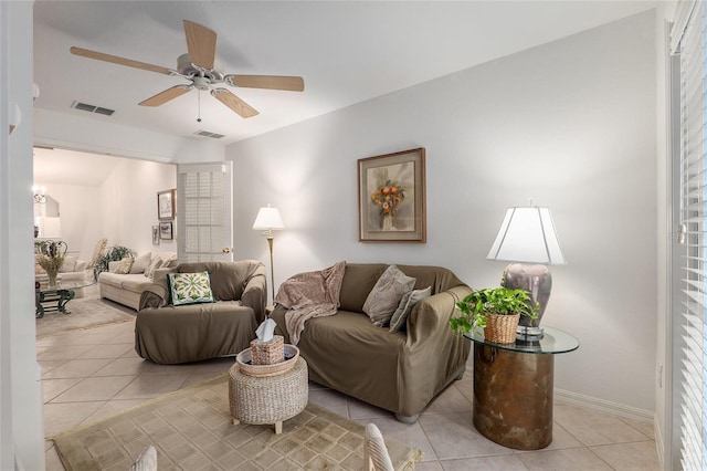 living area with ceiling fan, light tile patterned flooring, visible vents, and baseboards