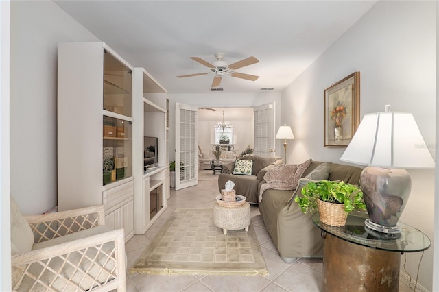 living room featuring ceiling fan with notable chandelier, visible vents, and light tile patterned floors