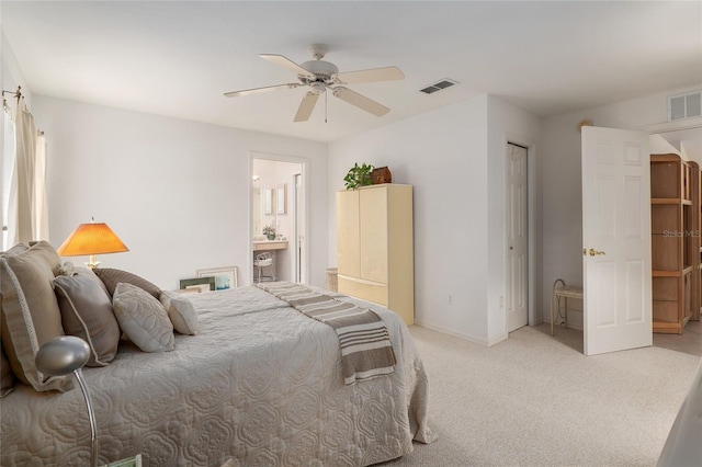 bedroom with light carpet, ensuite bath, ceiling fan, and visible vents