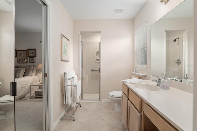 ensuite bathroom with ensuite bathroom, vanity, toilet, and tile patterned floors