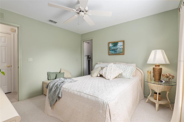 bedroom featuring a ceiling fan, visible vents, light carpet, and baseboards