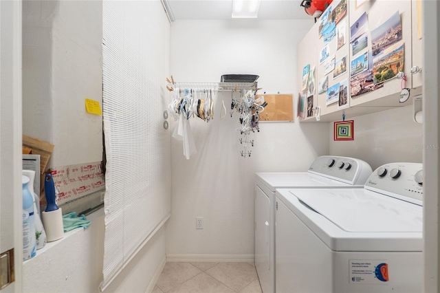 clothes washing area with cabinet space, washing machine and dryer, baseboards, and light tile patterned flooring