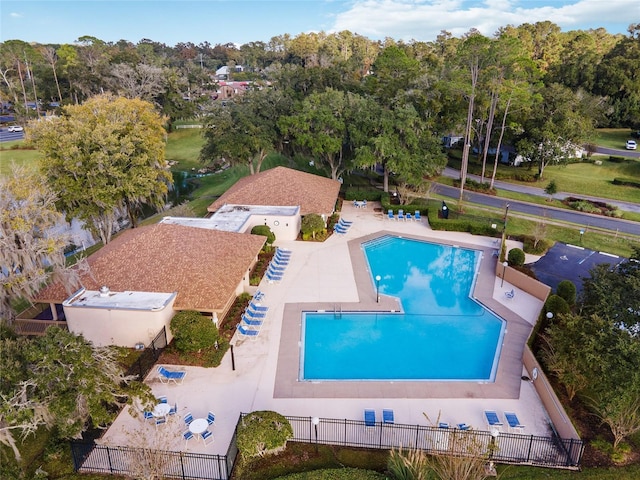 pool with a patio area and fence