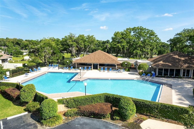 pool with a patio area and fence