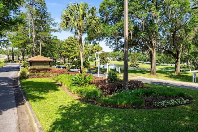 view of home's community featuring fence and a yard