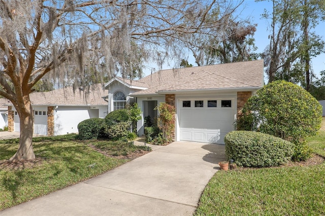 view of front facade with a garage, concrete driveway, a front lawn, and stone siding