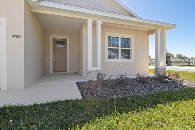 doorway to property featuring stucco siding