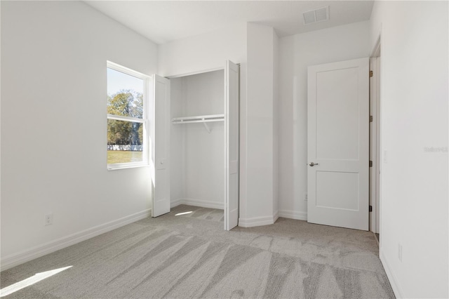 unfurnished bedroom featuring a closet, carpet, visible vents, and baseboards