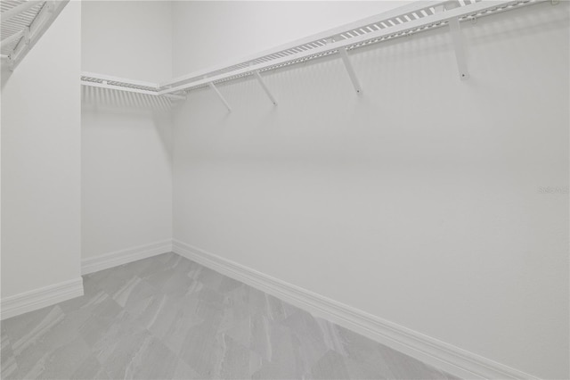walk in closet featuring light carpet
