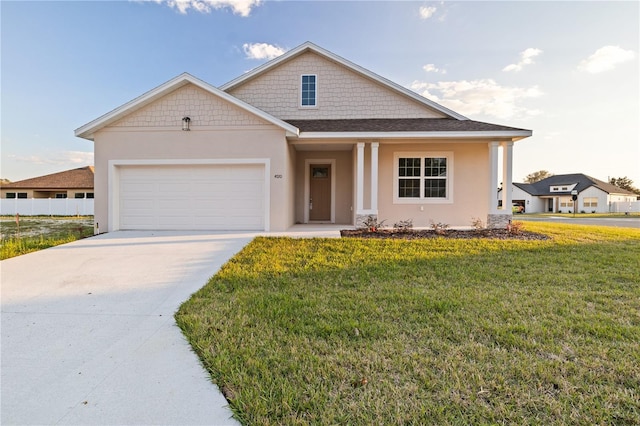 view of front of home with an attached garage, concrete driveway, a front yard, and stucco siding