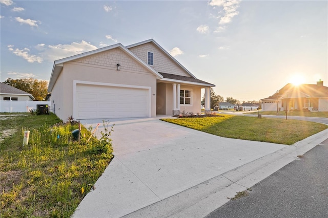 single story home with a front yard, an attached garage, fence, stucco siding, and driveway