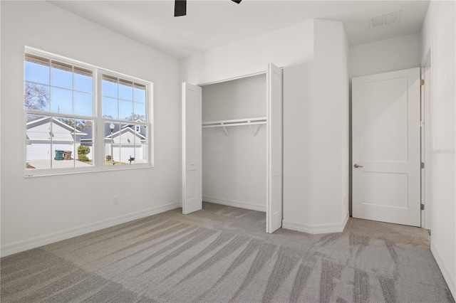 unfurnished bedroom featuring a closet, baseboards, carpet flooring, visible vents, and ceiling fan