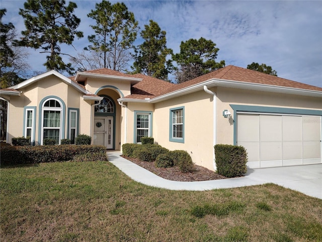 view of front of property featuring stucco siding, a shingled roof, a garage, driveway, and a front lawn