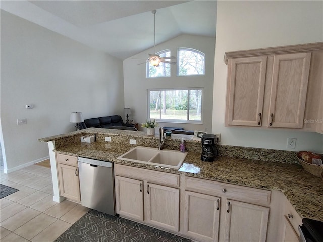 kitchen featuring lofted ceiling, light tile patterned flooring, a peninsula, a sink, and stainless steel dishwasher