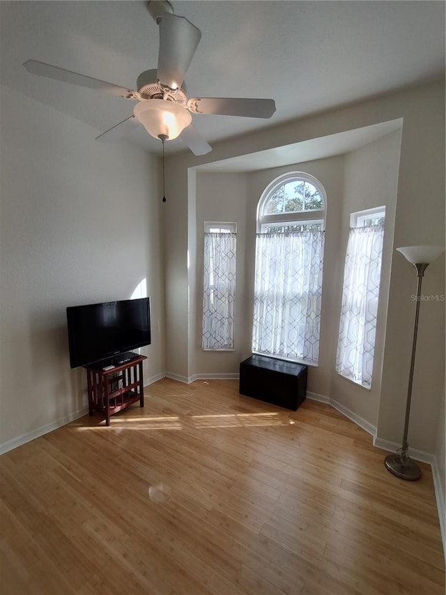 interior space featuring baseboards, ceiling fan, and light wood-style floors