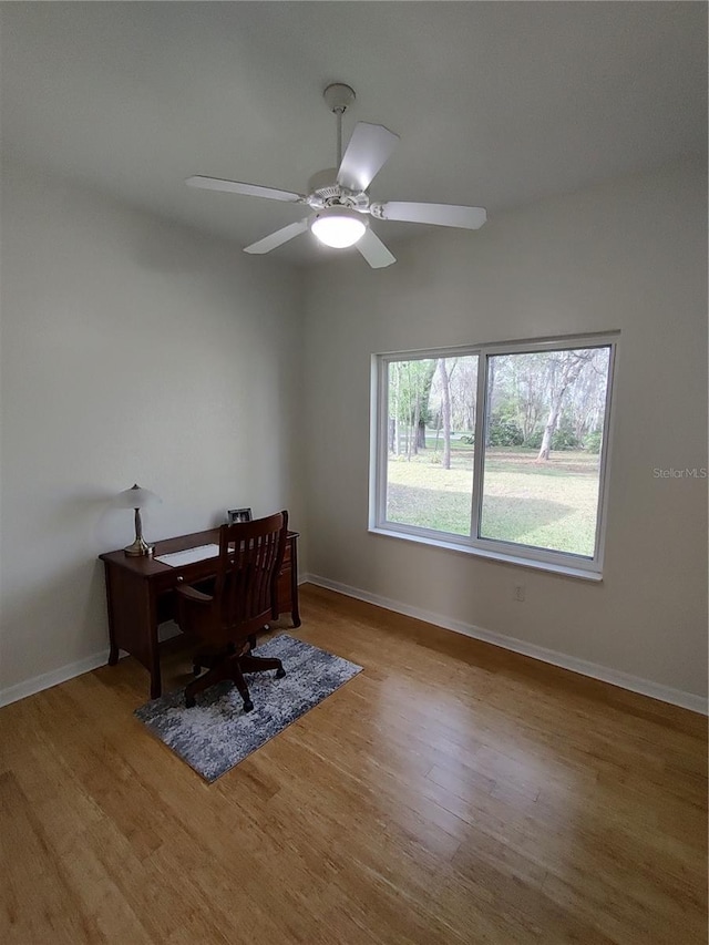 home office with light wood-style floors, ceiling fan, and baseboards