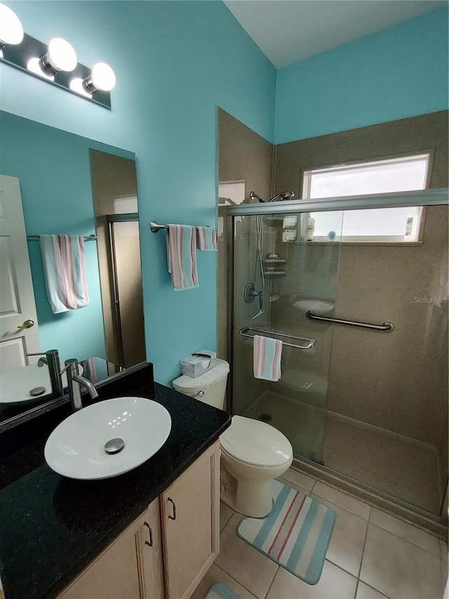 full bath with a shower stall, tile patterned flooring, toilet, and vanity