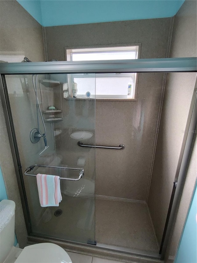 bathroom featuring a stall shower and toilet