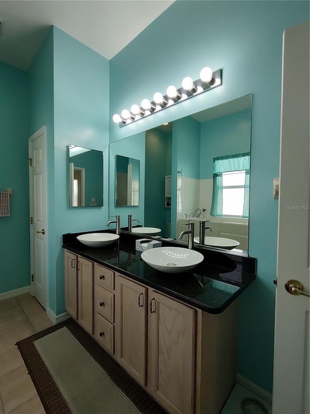 full bathroom with double vanity, a sink, and tile patterned floors