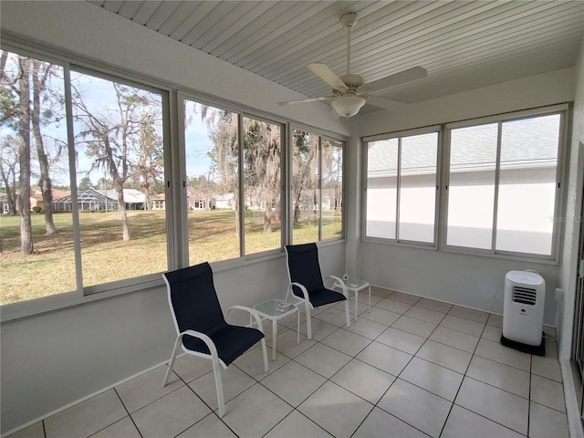 unfurnished sunroom featuring a ceiling fan