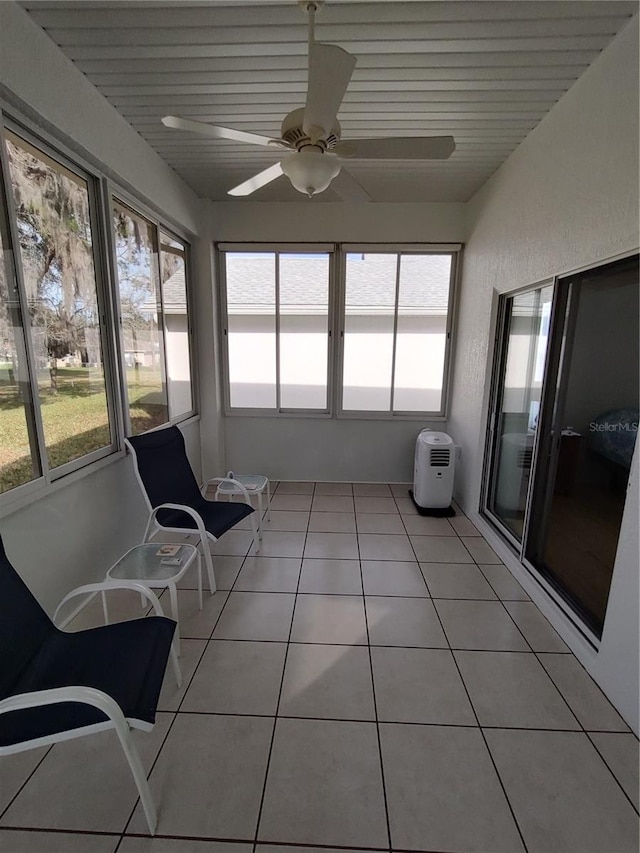 unfurnished sunroom featuring ceiling fan