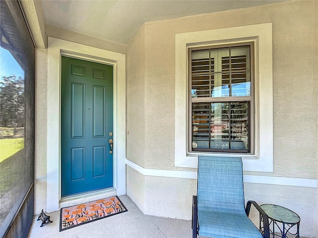 view of exterior entry featuring stucco siding