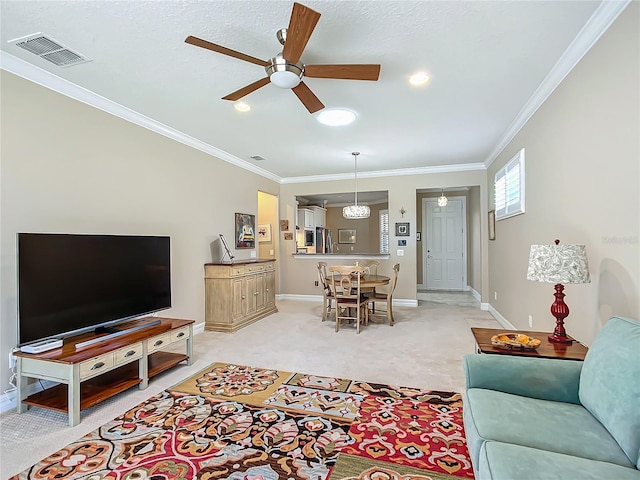 living area with ceiling fan, light carpet, visible vents, baseboards, and ornamental molding