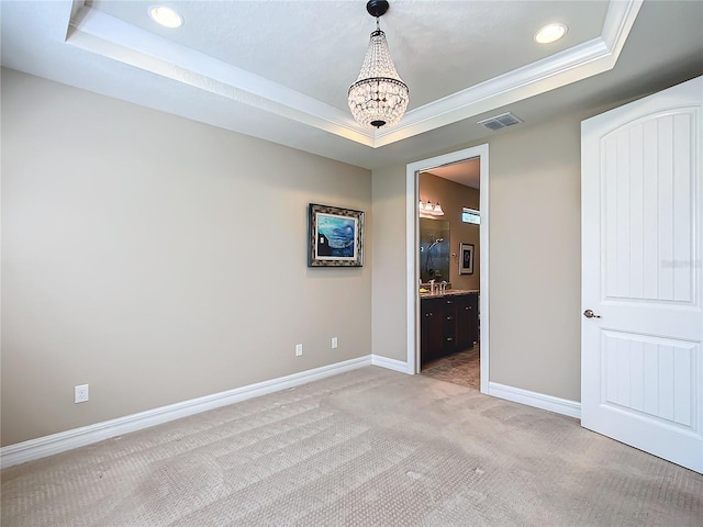 unfurnished room with light carpet, baseboards, visible vents, and a tray ceiling