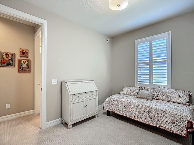 bedroom with light carpet and baseboards