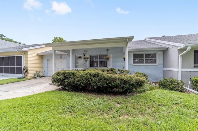 view of front of property with a garage, driveway, brick siding, and a front yard