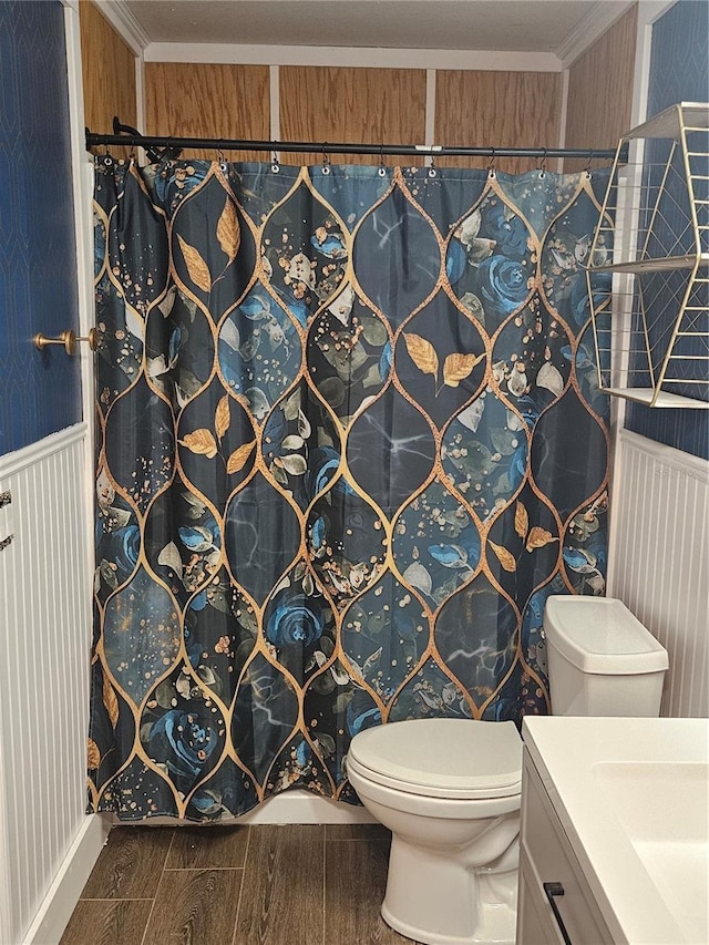 full bathroom featuring wood finish floors, crown molding, vanity, and toilet