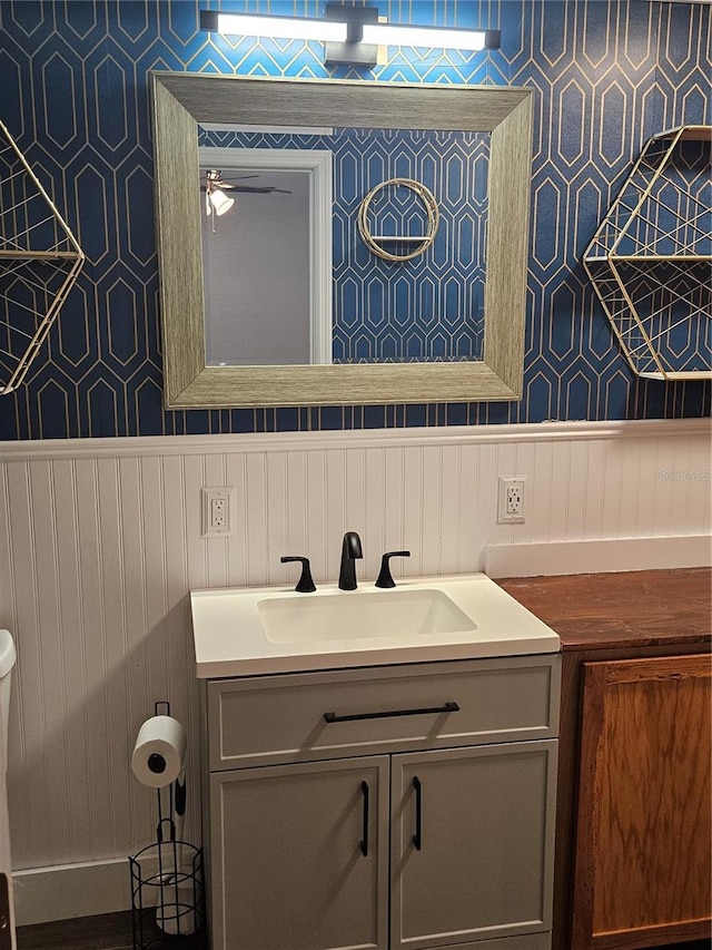 bathroom featuring a wainscoted wall, vanity, and toilet