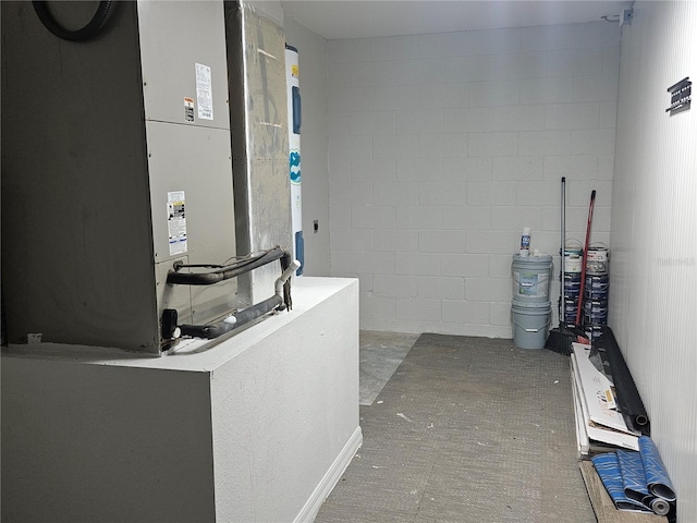 interior space with concrete block wall and heating unit