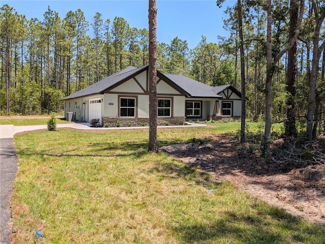 view of property exterior with a garage, driveway, stone siding, stucco siding, and a yard