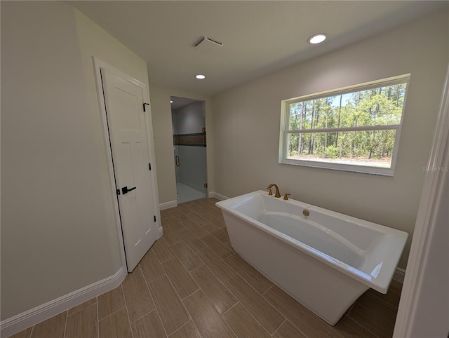 full bath with a freestanding tub, baseboards, a shower stall, and recessed lighting
