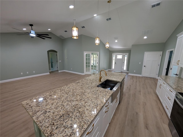 kitchen with visible vents, arched walkways, a sink, light wood finished floors, and stainless steel range with electric cooktop