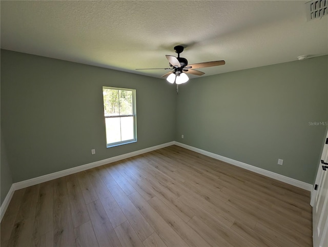 unfurnished room with visible vents, wood finished floors, baseboards, a textured ceiling, and a ceiling fan