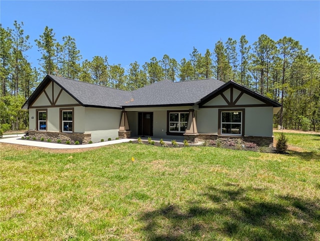 view of front of home with stone siding, a front yard, and stucco siding